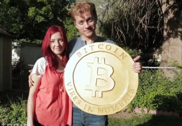 мужчина и девушка держат монету биткоин